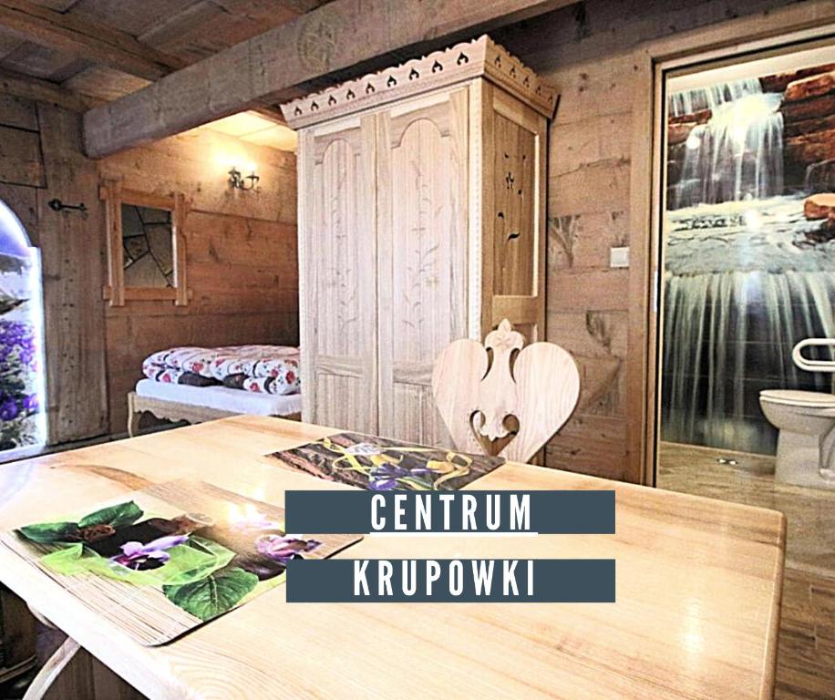 Habitación con mesa y habitación con cama en Góralski Domek Waluś Zakopane - ŚCISŁE CENTRUM - Jedyny domek na Krupówkach en Zakopane