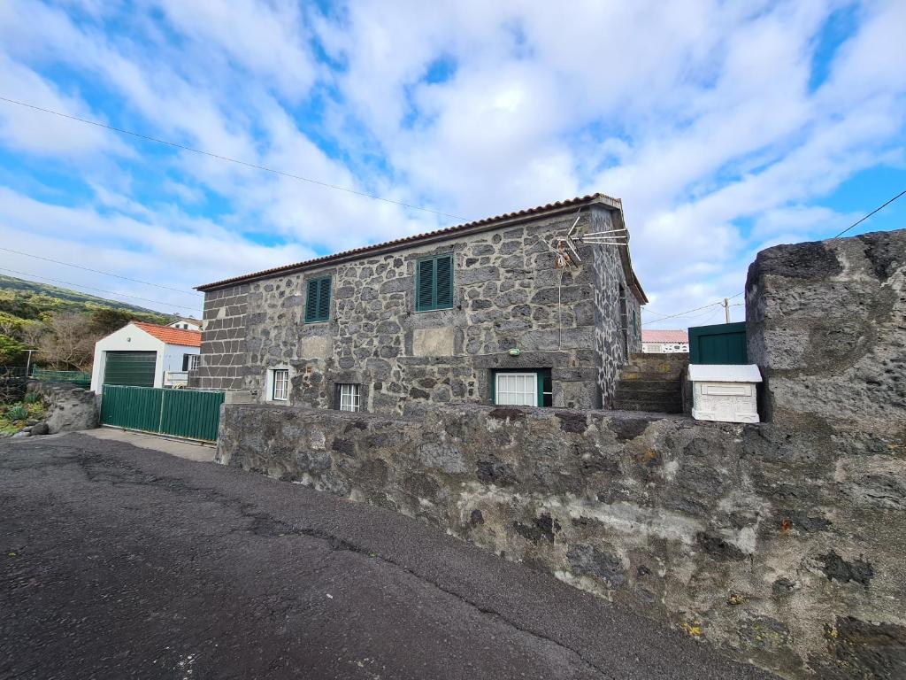 un ancien bâtiment en pierre situé sur le côté d'une route dans l'établissement Adega do Costa, à Prainha de Baixo