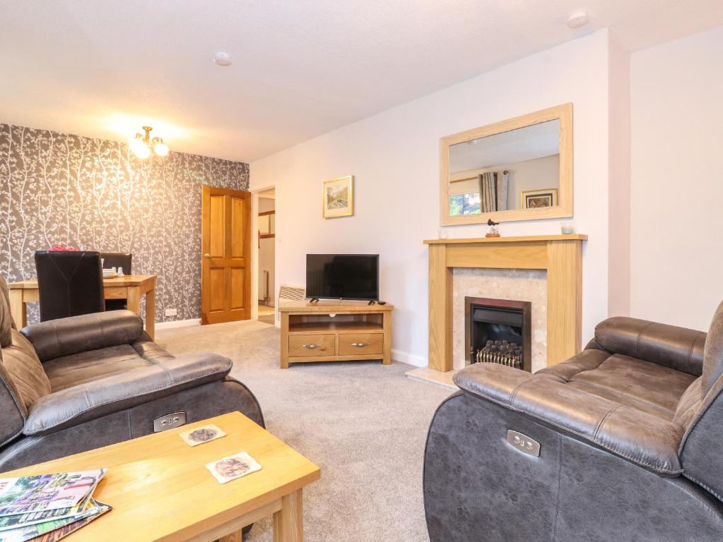uma sala de estar com dois sofás e uma lareira em Afton em Ambleside