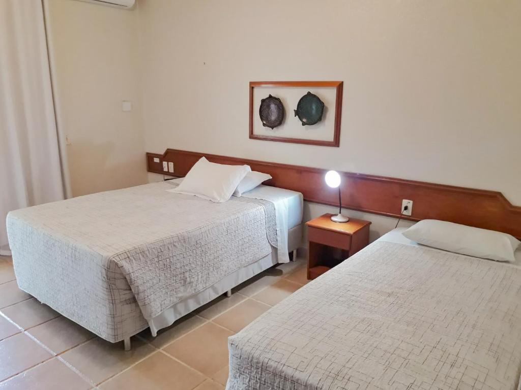 una habitación de hotel con 2 camas y una lámpara en Beloalter Hotel, en Alter do Chao