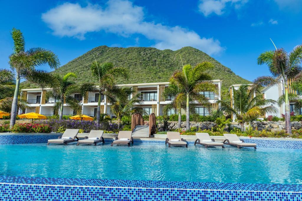 uma piscina de resort com espreguiçadeiras e um resort em Golden Rock Dive and Nature Resort em Oranjestad