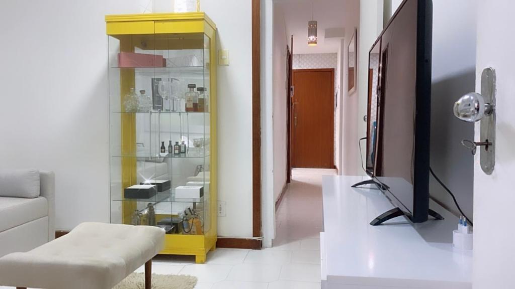 a living room with a yellow cabinet and a television at Aconchegante apartamento a Copacabana in Rio de Janeiro
