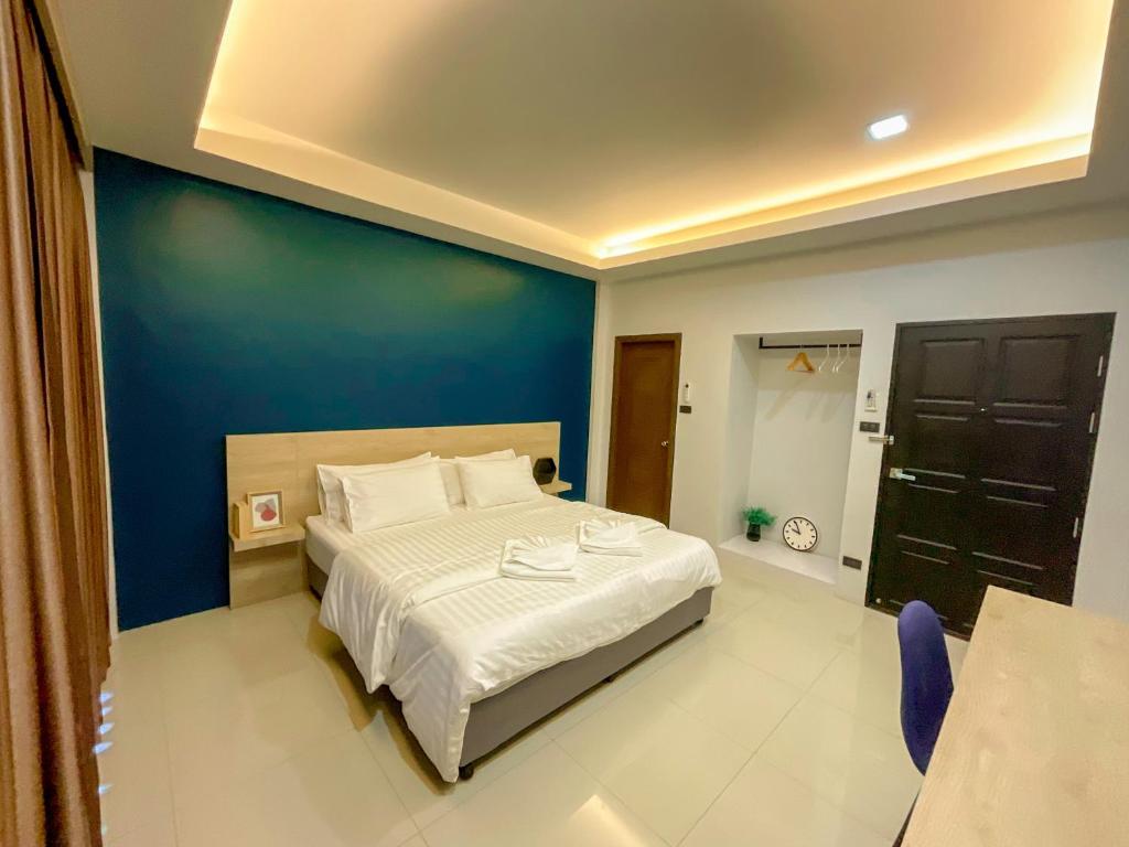 卡塔海灘的住宿－Tall Tree Kata Phuket，一间卧室设有一张蓝色墙壁的大床
