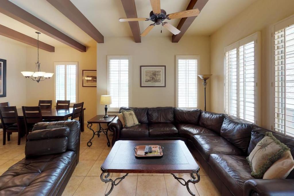 a living room with a leather couch and a table at LV305 Legacy Villas Townhome w Expansive Patio in La Quinta