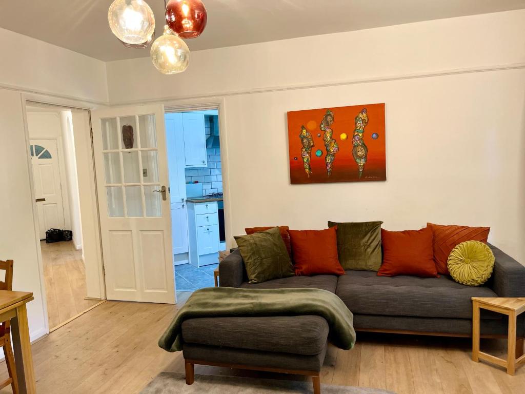 倫敦的住宿－Lovely 2 bed Hampstead Apartment，客厅配有沙发和墙上的绘画