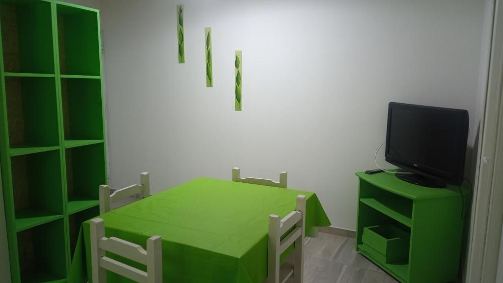 a green table and a television in a room at Departamento para 4 primer piso in Valeria del Mar