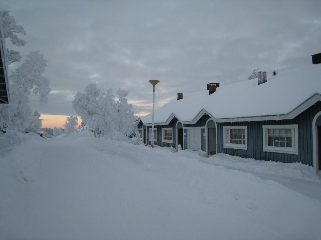 una pila de nieve delante de una casa en Saariselän Marjamajat, en Saariselkä