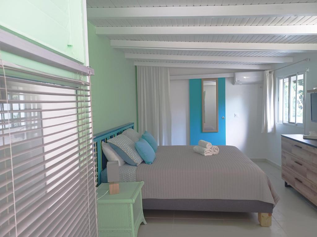 a bedroom with a bed with blue and white walls at La Rose du Bresil Marie-Galante in Capesterre