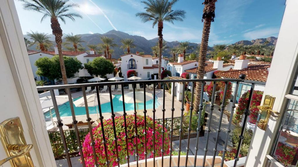 a balcony with a view of a pool and palm trees at SV006 Secluded Spa Villa Studio at LQ Resort in La Quinta