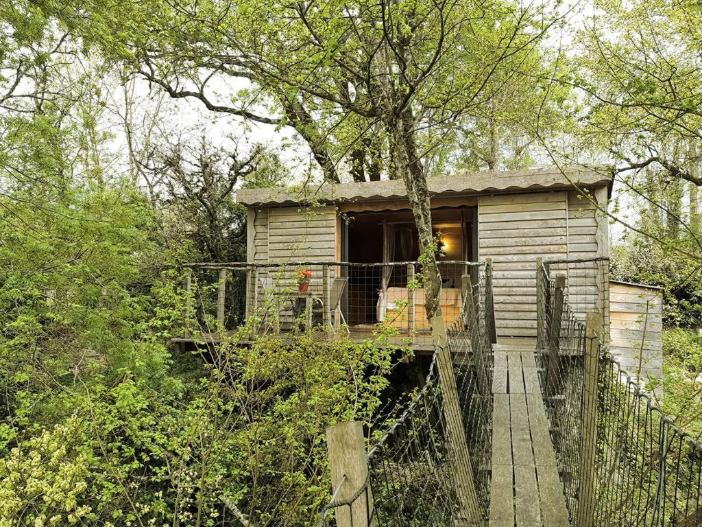 een houten huis met een houten loopbrug die naar het huis leidt bij Les Cabanes de Brassac in Brassac