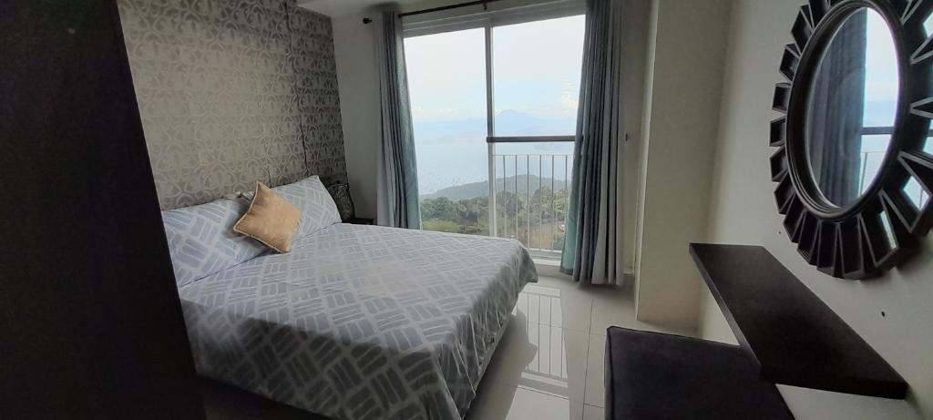 een slaapkamer met een bed en een groot raam bij Rm Staycation TaalView Smdc in Tagaytay