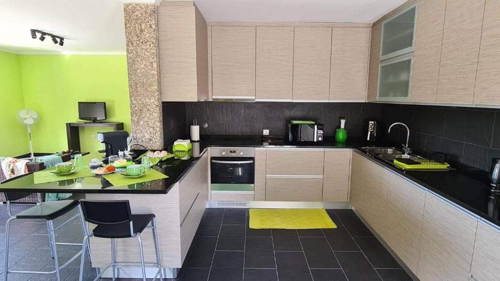 a kitchen with a counter and chairs in it at Modern Three Bedroom House in Figueiró