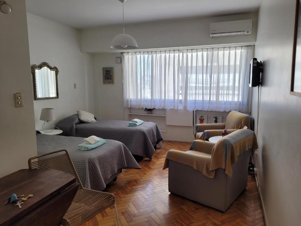 sala de estar con 2 camas y sofá en Alto Santa Fe en Buenos Aires
