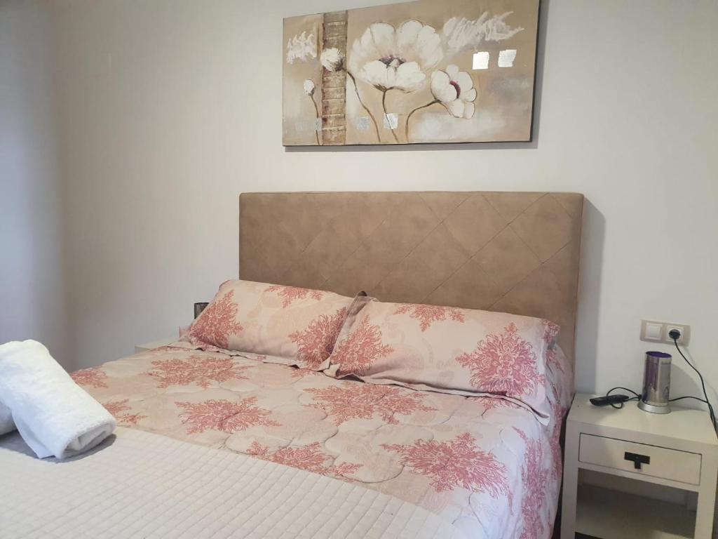 Un dormitorio con una cama con flores rosas. en CASA NOGUEIRA, en Allariz