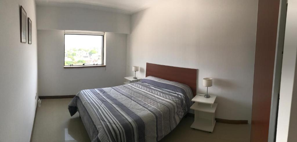 um pequeno quarto com uma cama e uma janela em Departamento de categoría en macrocentro Echeverria em Río Cuarto