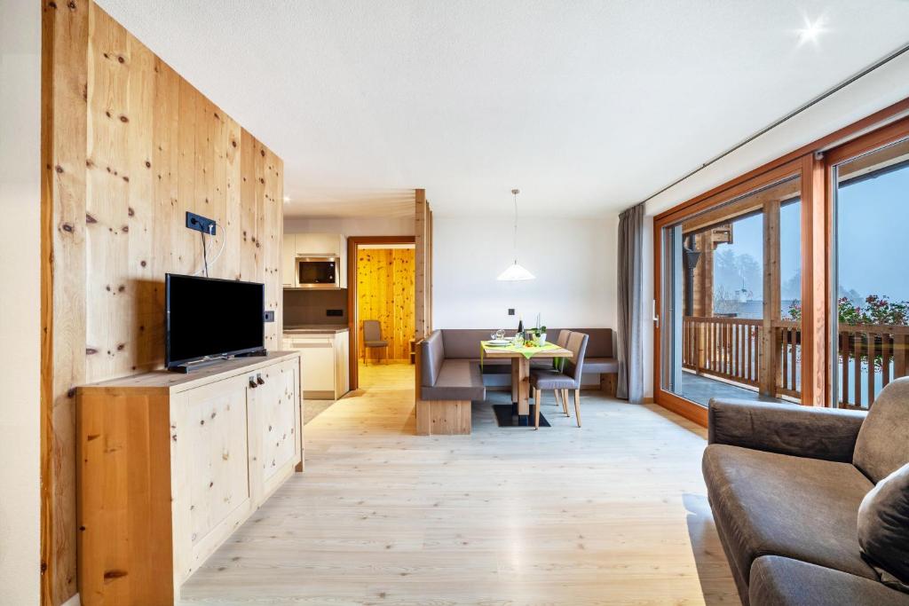 a living room with a couch and a television at Residence Kalchgruberhof Zirbe in Santa Valpurga