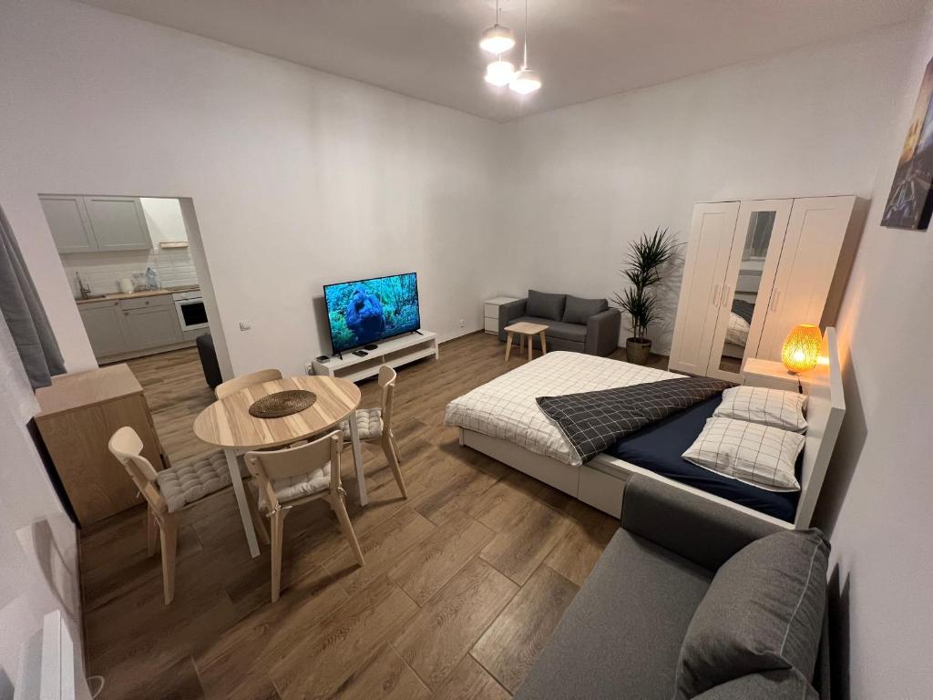 1 dormitorio con cama, mesa y sofá en Paris Apartments, en Katowice