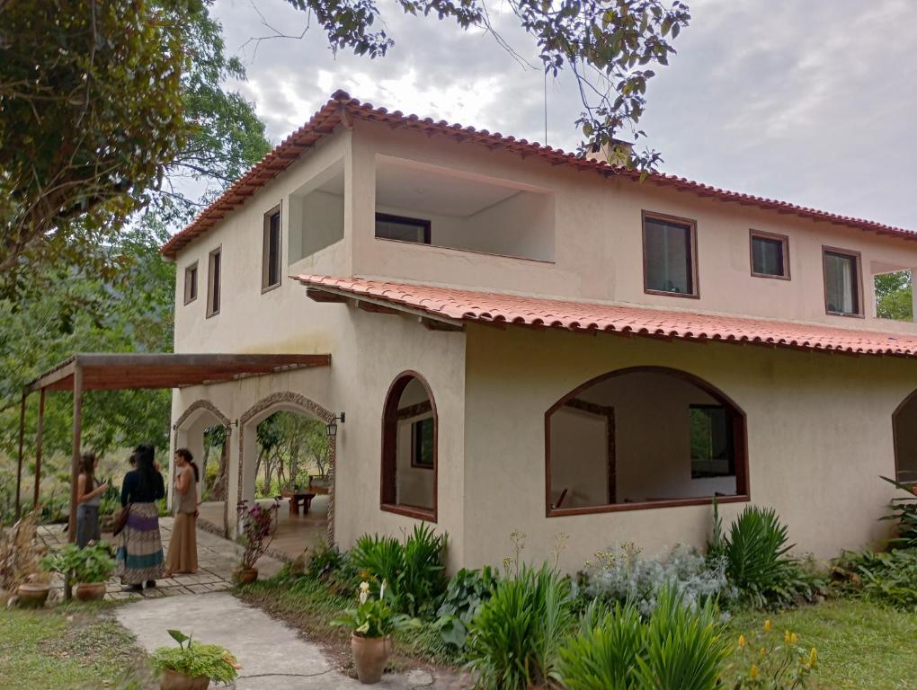 a house with two people standing outside of it at Pousada Canto das Cachoeiras in Vale do Capao