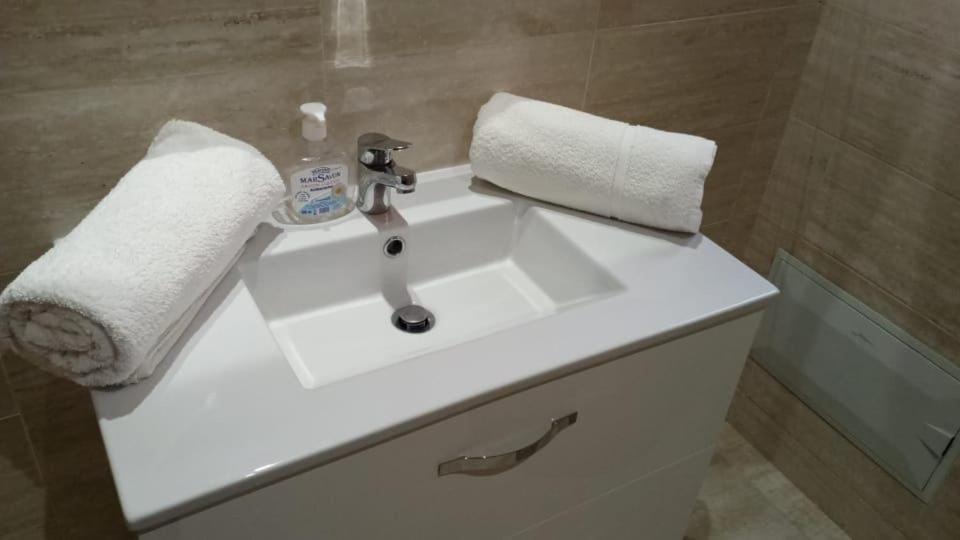 a white bathroom sink with a soap bottle on it at Prestigia golf piscine appartement lux opale 3 chambre in Marrakesh