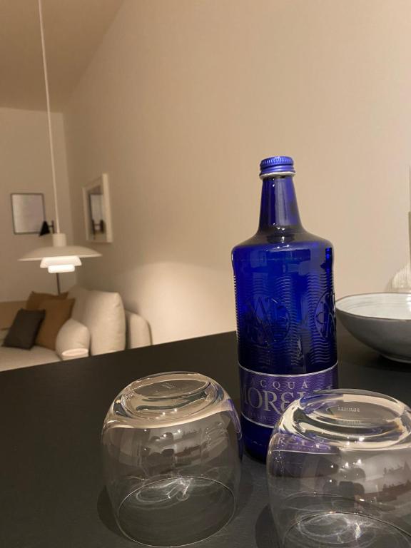 a blue bottle and two glass bowls on a table at Modernes City Apartment im Scandinavian Design in Hamburg