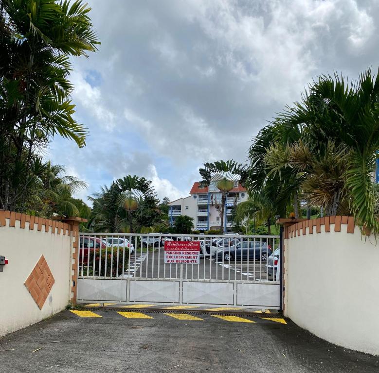 een poort op een parkeerplaats met palmbomen bij f3 location saisonnière détente tranquillité et belle vue in Les Trois-Îlets