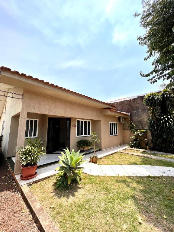 una pequeña casa con un jardín frente a ella en Casa Aconchegante no Centro de Foz do Iguaçu, en Foz do Iguaçu