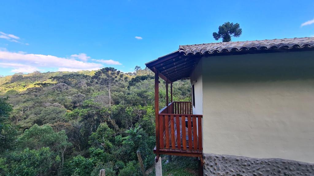 a building with a balcony with a view of a mountain at Casa Sol Brilhante - natureza e riacho na varanda in Gonçalves