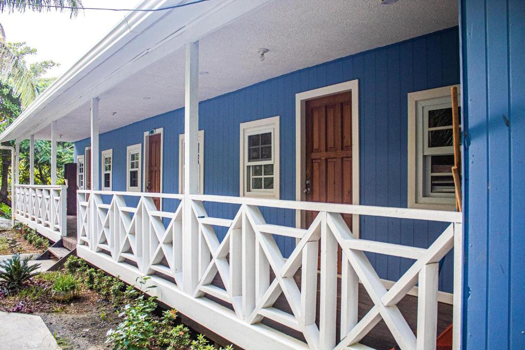 a blue and white house with a white fence at Coco Bahia Apartment in Six Huts