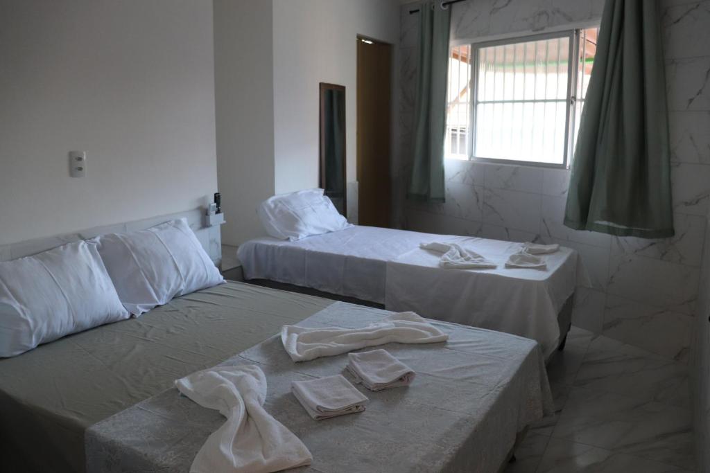 een hotelkamer met twee bedden met handdoeken erop bij Suítes Mar de Maragogi in Maragogi