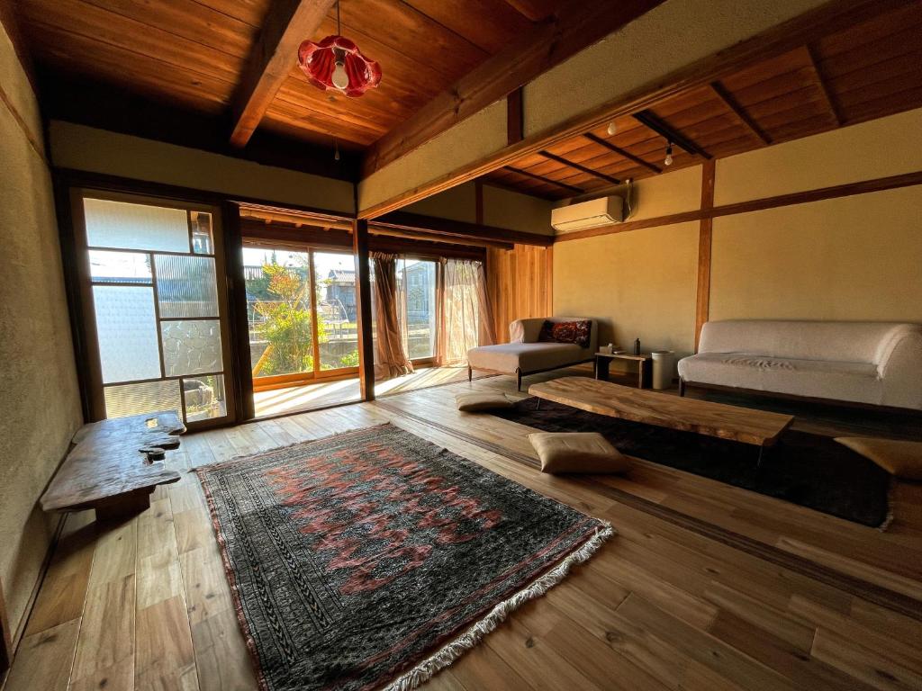 ein Wohnzimmer mit einem Bett und einem Teppich in der Unterkunft 淡路島 サササウナ in Awaji