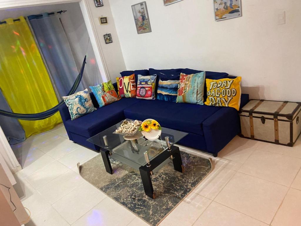 - un canapé bleu avec des oreillers et une table dans le salon dans l'établissement Precioso apartamento, residencial ideal familia, à Saint-Domingue