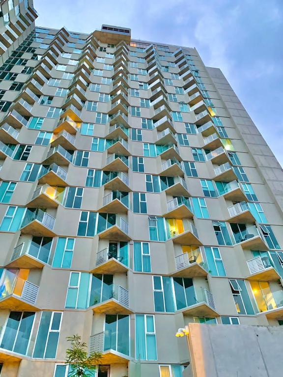 un edificio de apartamentos alto con ventanas azules en Único Apartamento en Nuevo y Moderno Condominio, en San José