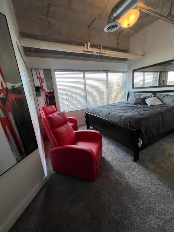 a bedroom with a bed and a red chair at Grand 3br loft in Atlantic Station in Atlanta