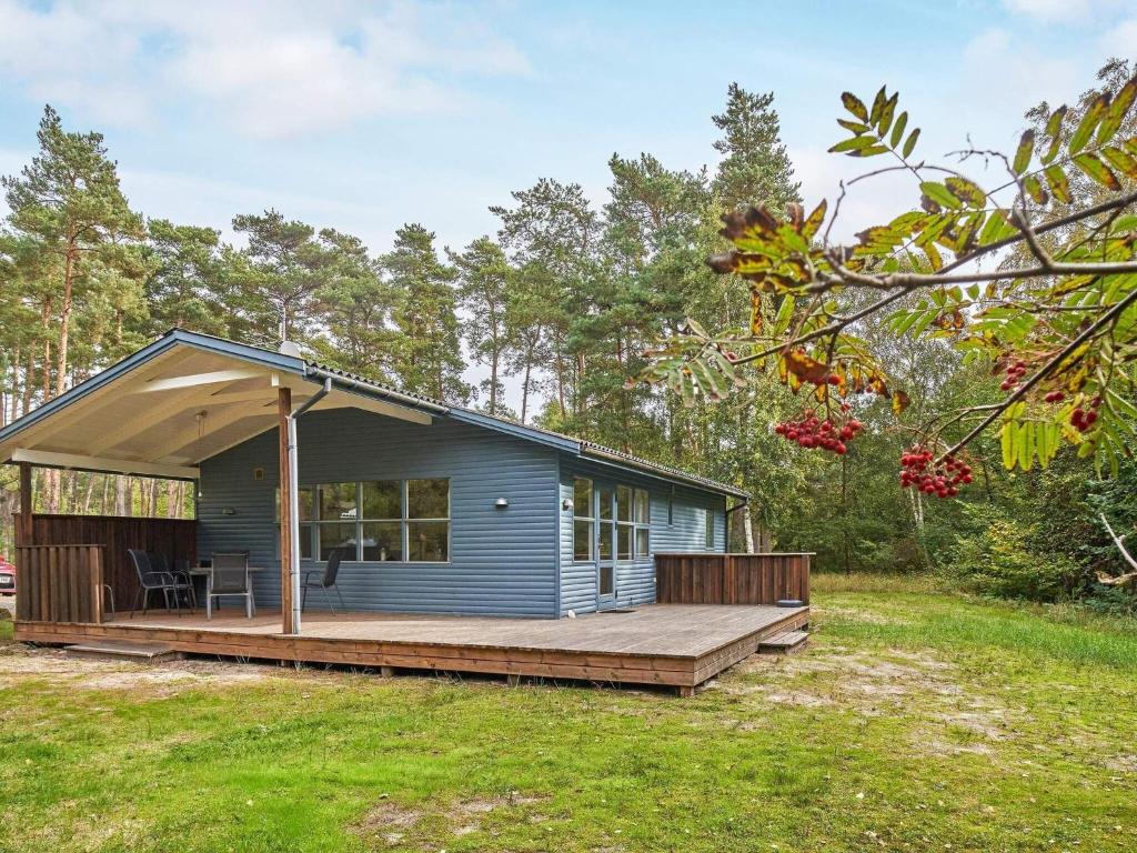 a small blue house with a wooden deck at Holiday home Aakirkeby XXXIX in Vester Sømarken