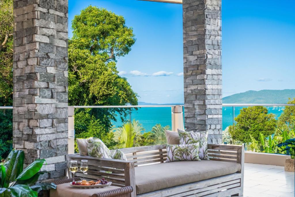 a patio with a bench and a view of the ocean at Holiday Haven Whitsundays in Cannon Valley