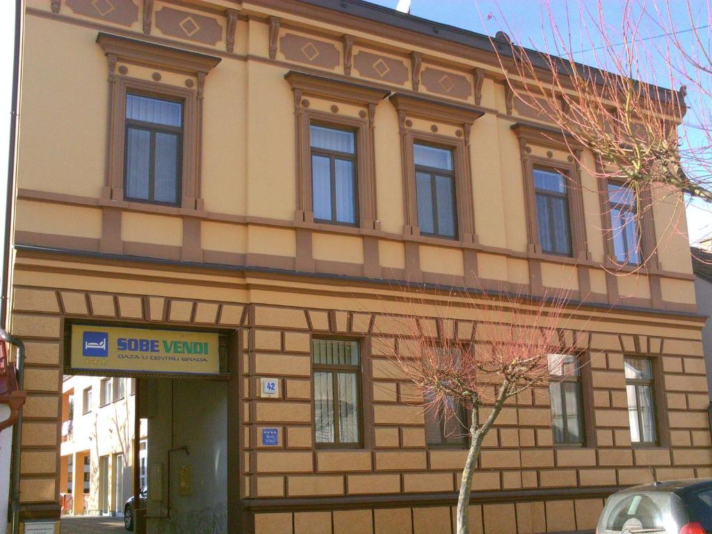 a building with a sign in front of it at Rooms Vendi in Daruvar