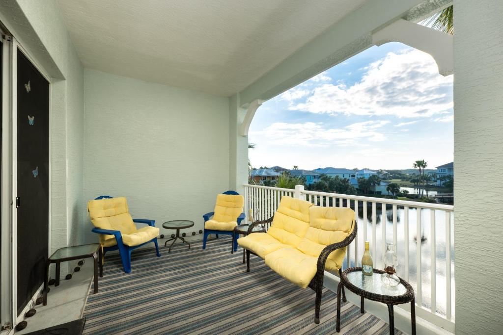 a balcony with chairs and a table and a view at 933 Cinnamon Beach, 3 Bedroom, Sleeps 8, 2 Pools, Elevator, WiFi in Palm Coast