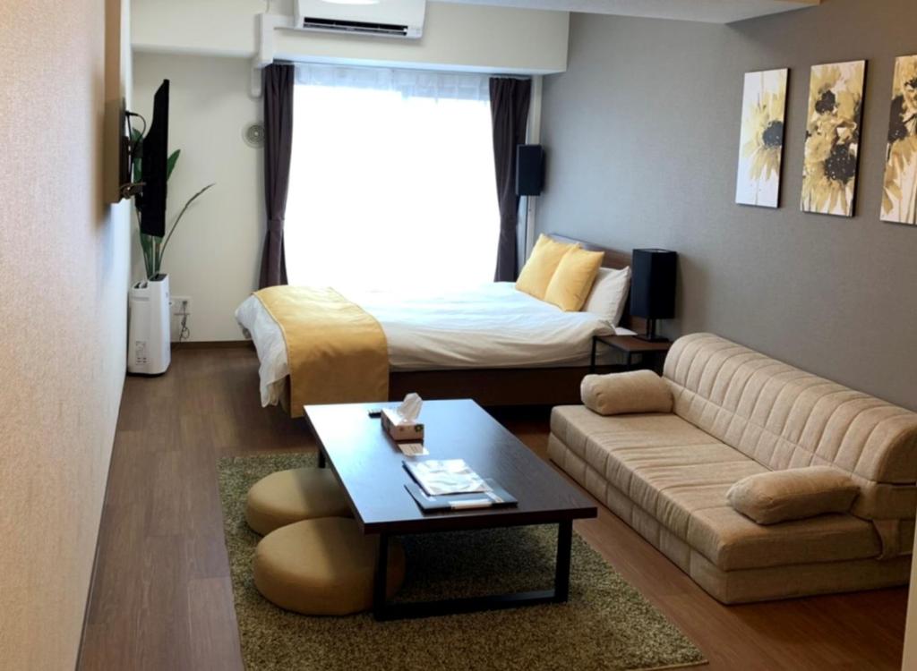 een woonkamer met een bank en een bed bij RLiS-house Shin-Osaka Kita - Vacation STAY 9516 in Osaka