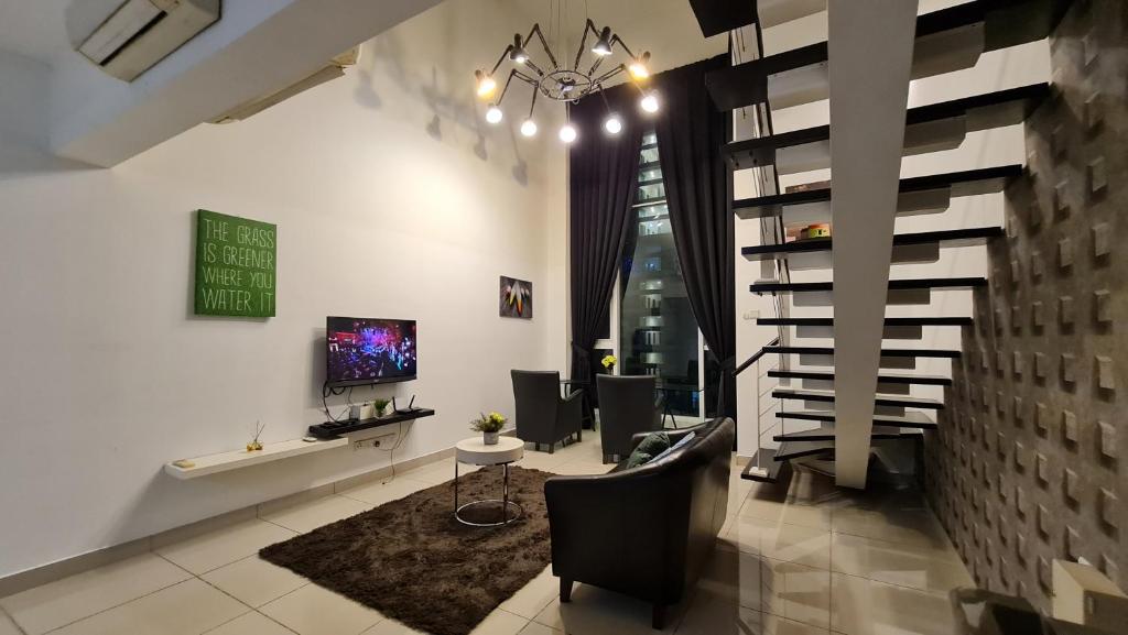a living room with black chairs and a staircase at Premium 5STAR Resort Suite Mid Valley KL Sunway by Stayz Suites with Shopping Complex in Kuala Lumpur