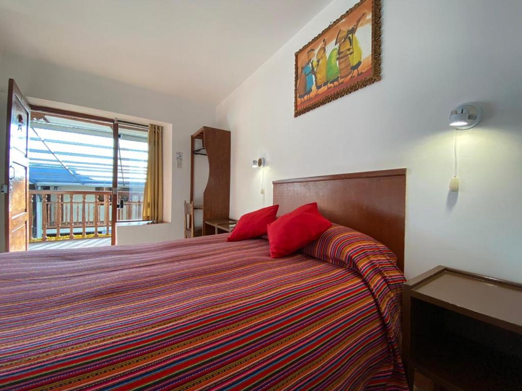 1 dormitorio con 1 cama grande con almohadas rojas en Hostal Saphi - Excelente ubicación, en Cusco