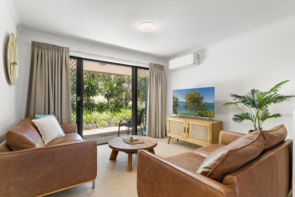 a living room with two couches and a table at Modern & Stylish 2 Bedroom Townhouse in Noosaville