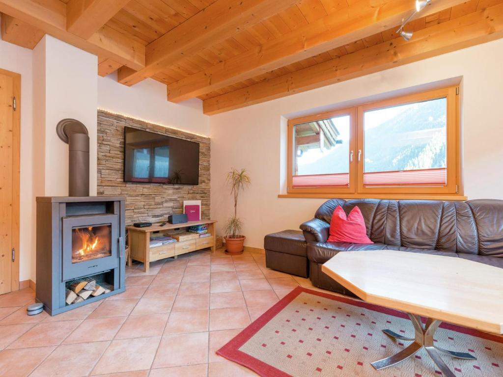 a living room with a couch and a fireplace at Chalet Wasserfall, Krimml in Krimml