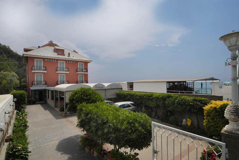 un balcone di un edificio con auto parcheggiate di fronte di Hotel Lido a Deiva Marina