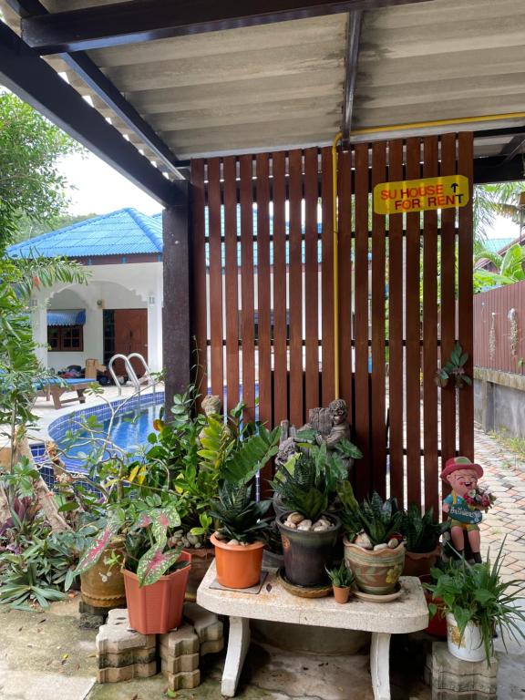 una valla de madera con plantas sobre una mesa junto a una piscina en SU house Koh Phangan, en Thong Nai Pan Yai