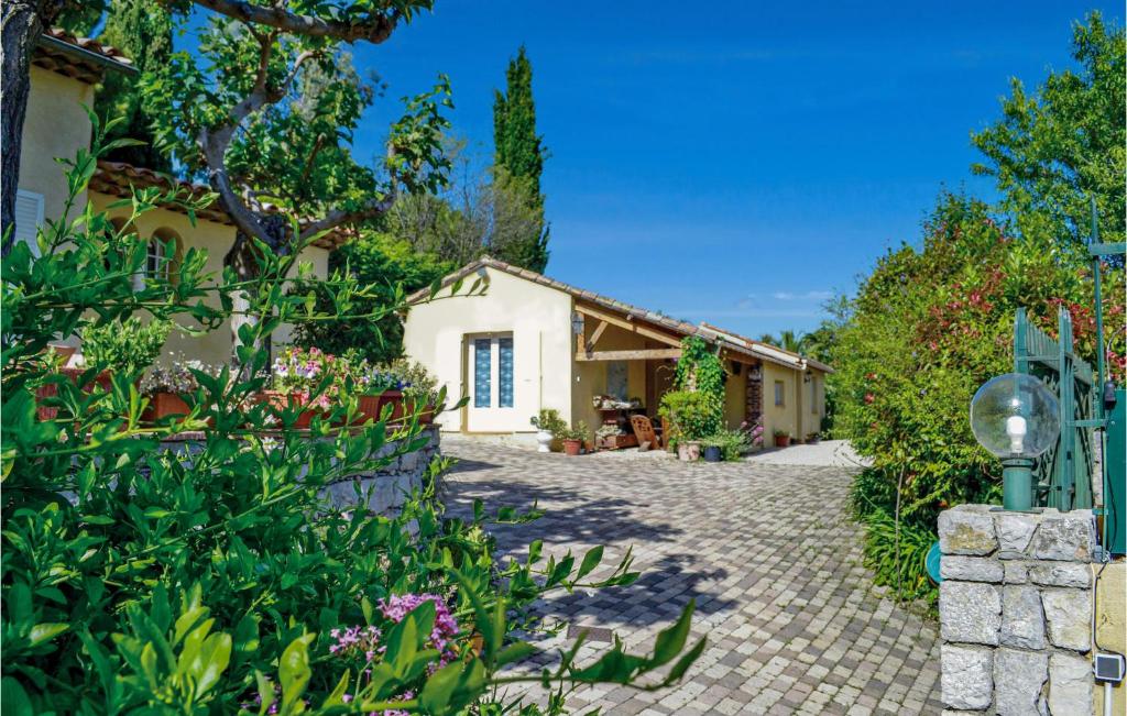 a house with a garden and a brick driveway at Awesome Home In Mougins With 2 Bedrooms, Wifi And Outdoor Swimming Pool in Mougins