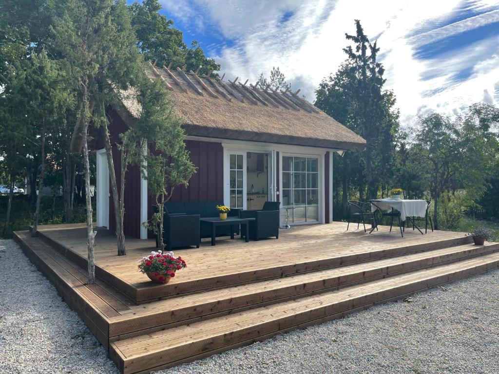 a house with a wooden deck with a table and chairs at Käspri Farmstay in Koguva