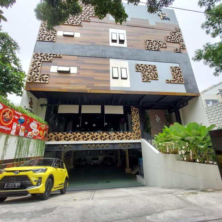 3 Point Syariah Residence في جاكرتا: سيارة صفراء متوقفة أمام مبنى