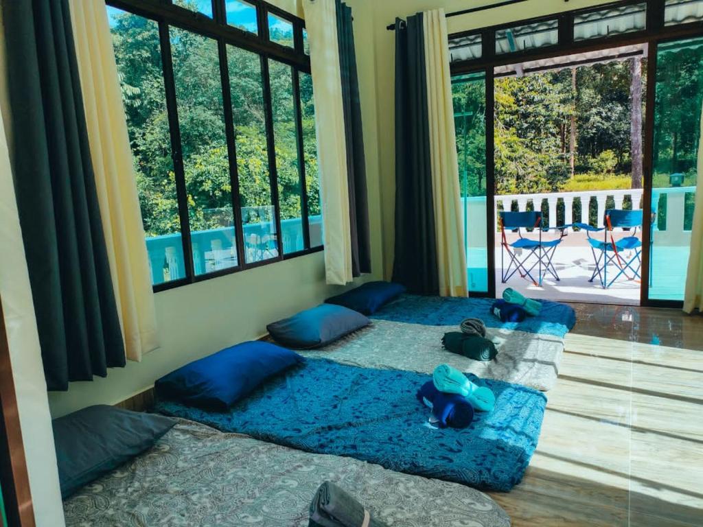 Dango1881muslim riverstay في Padang Rengas: غرفة نوم مع سرير ذو أغطية زرقاء ومخدات زرقاء