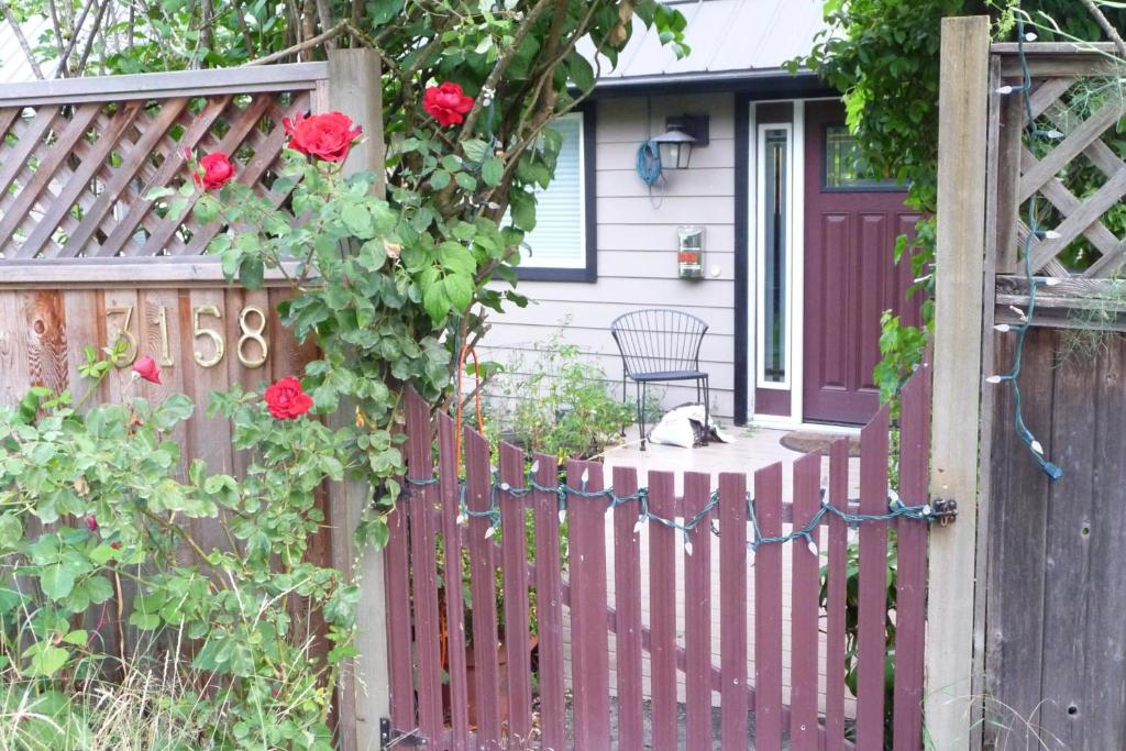 a wooden fence with red roses on it at Cycle Inn Bed and Breakfast in Langford