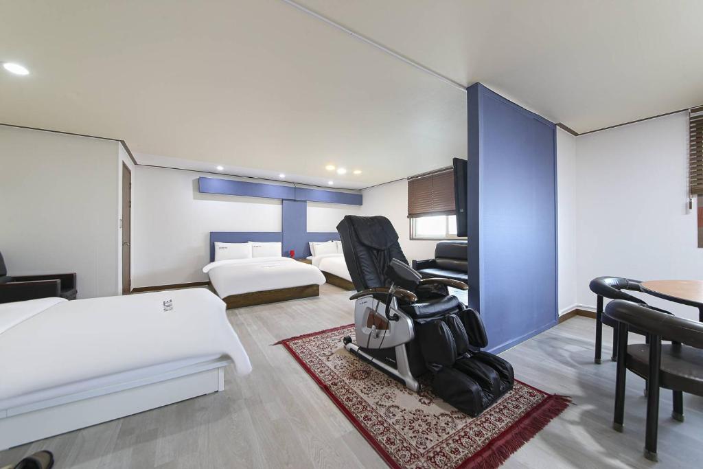 a hotel room with two beds and a dining table at XO Hotel in Jeonju